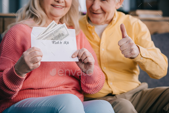 n while holding envelope with ‘roth ira’ lettering