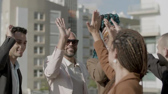 Medium Shot of Excited Colleagues Giving High Five to Each Other