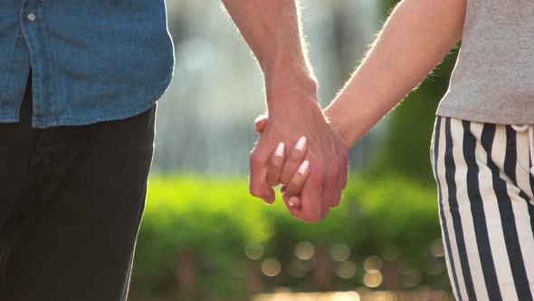 Young Couple Joining Hands Outdoors