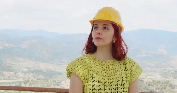 Young female engineer looks at the panorama from the mountain