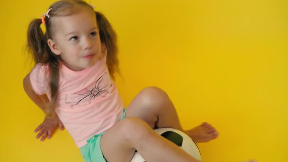 Authentic Cute Smiling Preschool Little Girl with Classic Black and White Soccer Ball Look at Camera