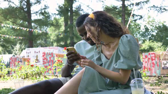 Young Multiracial Couple Watches Taken Photos in Phone