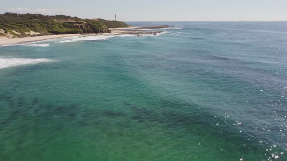 aerial approaching clip of pebbly beach and norah head lighthouse