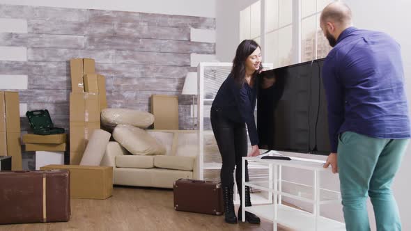 Young Couple Carrying Big Tv in Their New Apartment