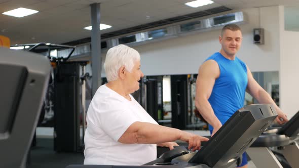 Happy Smiling People are Engaged in Physical Education Simulators in Gym