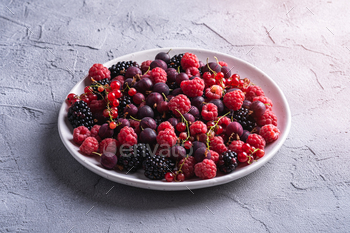 Tasty fresh ripe raspberry, blackberry, gooseberry and red currant berries in plate / Photodune, Misc