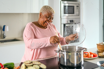 Happy senior woman preparing lunch in modern kitchen / Photodune, Misc