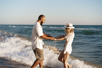 Young beautiful couple walking on beach near sea / Photodune, Misc