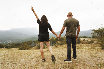 Back view of couple standing and looking at foggy mountains / Photodune, Misc