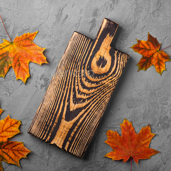 Handcrafted old wooden cutting board with autumn leaves / Photodune, Misc