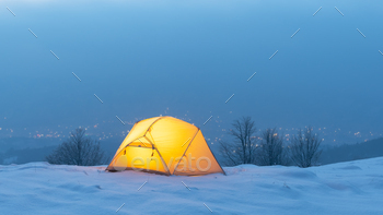 Yellow tent lighted from the inside against the backdrop of glowing city lights / Photodune, Misc