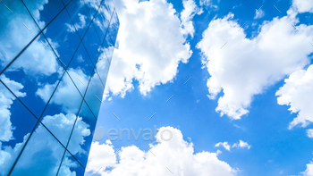clouds reflected in the many mirrored facets of a modern office building / Photodune, Misc