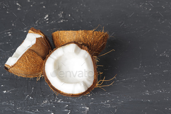 Cracked coconut pieces on dark wooden background / Photodune, Misc