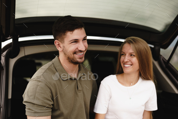 Young happy couple on a road trip sitting in car trunk / Photodune, Misc