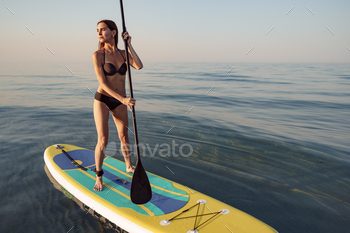 Young attractive woman standing on paddle board / Photodune, Misc