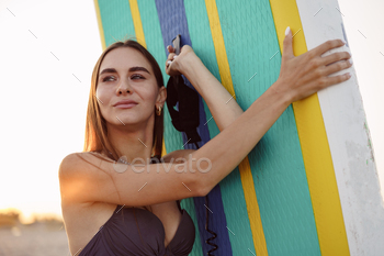Attractive young woman in swimsuit posing with stand up paddle board / Photodune, Misc