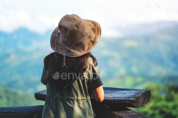 A female traveler standing back and looking at beautiful green mountain / Photodune, Misc