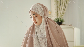 Muslim women pray with greeting gestures wearing a mukenah / Photodune, Misc