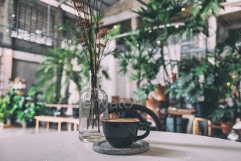 A black cup of hot coffee on table in cafe / Photodune, Misc