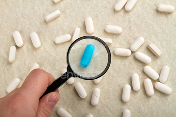 Zooming pills using magnifier glass. / Photodune, Misc