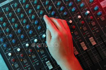 The musician adjusts the sound on audio mixer / Photodune, Misc