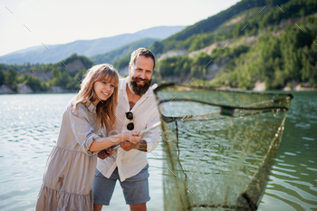 Happy preteen girl and father with fishing net on summer holiday by lake / Photodune, Misc