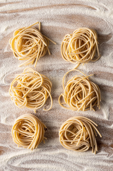 Italian pasta nest. Uncooked spaghetti nest and flour. / Photodune, Misc