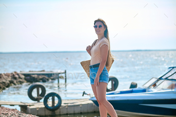 A woman in shorts standing on the beach and feeling wonderful / Photodune, Misc