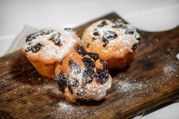 Taste cupcakes with raisins on the board. Close-up. The concept of food, pastries, desserts. / Photodune, Misc