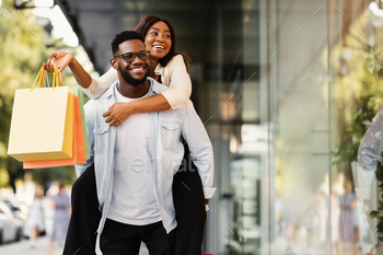 African American couple with shopping bags pointing at window / Photodune, Misc
