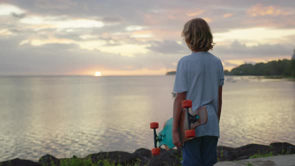 Portrait Boy with a Longboard on a Beautiful Road