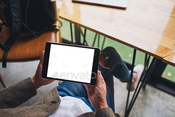 Top view mockup image of a woman sitting and holding black tablet pc with blank white desktop screen / Photodune, Misc