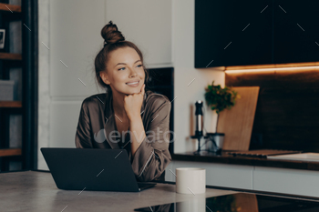 Young happy freelancer lady in cozy pajamas working from home on laptop / Photodune, Misc