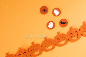 Halloween decoration with a pumpkin garland on an orange background / Photodune, Misc