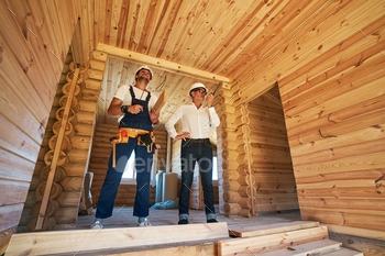 Structural engineer passing information through radio next to worker / Photodune, Misc