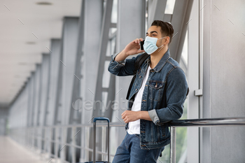Young Arab Man In Medical Mask Talking On Cellphone In Airport Terminal / Photodune, Misc
