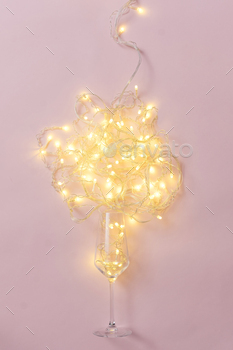 Glass of wine and garland with light bulbs on pink background minimal creative party concept. / Photodune, Misc