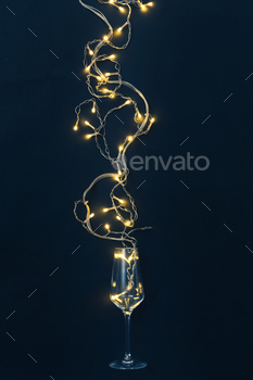 Glass of wine and garland with light bulbs on black background minimal creative party concept. / Photodune, Misc