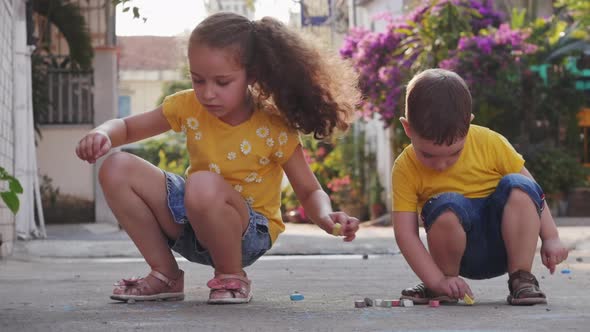 Funny Little Children Like To Play a Fun Game Together, Making Drawings with Colored Crayons