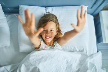 Little girl wakes up from sleep on a big and cozy bed white linen in the at home / Photodune, Misc