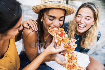 Three young female friends sitting outdoor and eating pizza / Photodune, Misc