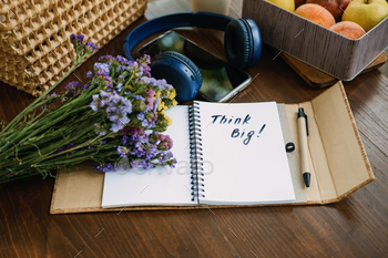 Think big motivational phrase in open notebook on the table. Outdoor still life with think big / Photodune, Misc