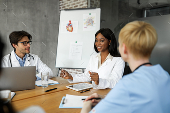 Black woman doctor with digital tablet talking to her colleagues / Photodune, Misc