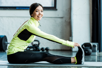 happy young woman stretching on fitness mat in gym / Photodune, Misc