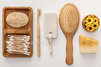 flat lay with wooden dish with cotton swabs and loofah near toothbrush, hairbrush, piece of soap, / Photodune, Misc