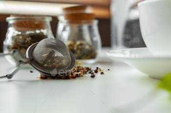 Glass jars with dry tea leaves close up on white table / Photodune, Misc