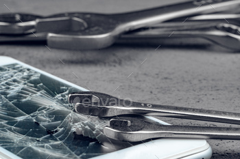 Crashed smartphone with repairing tools on grey background / Photodune, Misc