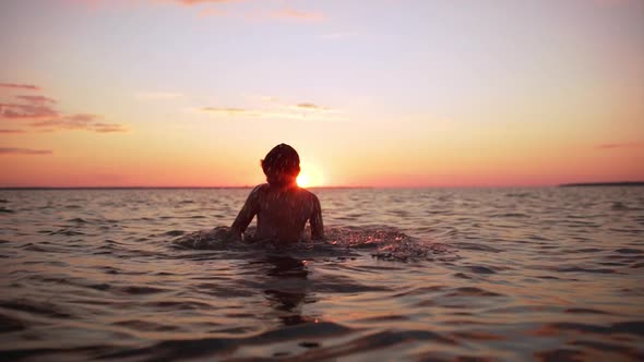 Portrait of Young European Boy 1012 Diving and Swimming in Sea Alone During Amazing Dusk in Slow