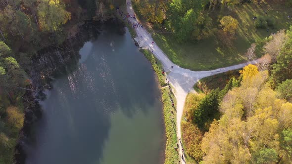 The People Walk in the Autumn Park Near the Lake