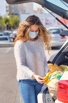 Young woman checking grocery bags in car trunk / Photodune, Misc